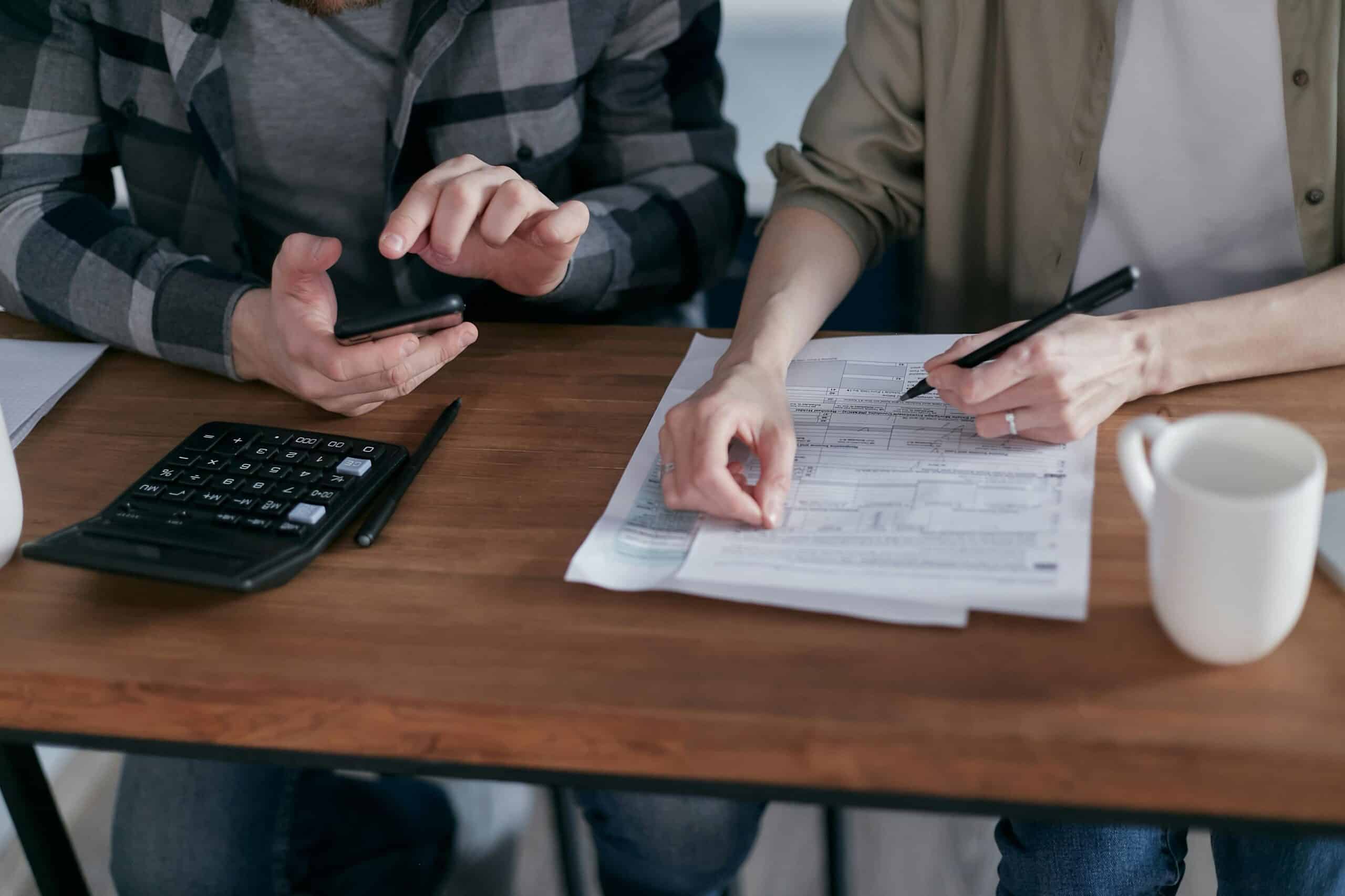 une personne qui écrit une autre qui tape sur une calculatrice